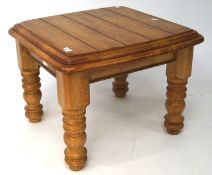A 20th century small wooden coffee table, with curved corners and edges, raised on turned supports,