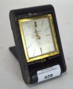 A Jaeger Le Coultre folding travel clock, the silvered dial with gilt hour markers,