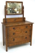 An early 20th century oak dressing table with a framed swing mirror