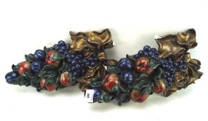 Two painted and gilt plaster wall hangings of fruit,