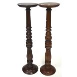 Two stained wooden jardiniere stands on turned and fluted supports and round foot,