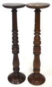 Two stained wooden jardiniere stands on turned and fluted supports and round foot,