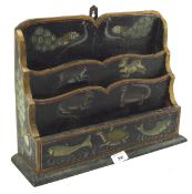 A late 19th/early 20th century letter rack painted and gilt with animals on a black ground,