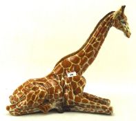 A large 20th century painted ceramic figure of a Giraffe, in a resting pose,