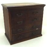 A stained oak collectors cabinet, with two short shelves over three long ones, on a plinth base,