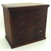 A stained oak collectors cabinet, with two short shelves over three long ones, on a plinth base,