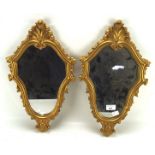 A pair of small wall mirrors, mounted in moulded gilt frames decorated with scrolls,