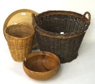 A vintage wicker twin handled log basket and other items, including a wooden bowl,