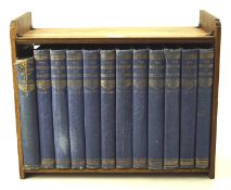 A vintage oak book rack containing 12 volumes of 'The Wonderland of Knowledge',