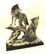 A Giuseppe Armani signed sculpture of two wolves, mounted on a wooden plinth,