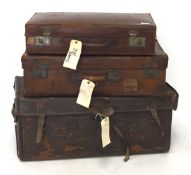 A vintage leather trunk and two suitcases, the trunk with side handles,