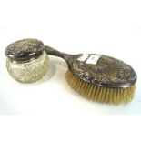 An Edwardian silver hair brush and a silver topped glass pot, both adorned with Reynolds Angels,