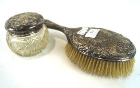 An Edwardian silver hair brush and a silver topped glass pot, both adorned with Reynolds Angels,