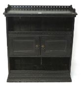 A late 19th century ebonised unit, with a central two door cupboard between two shelves and top,