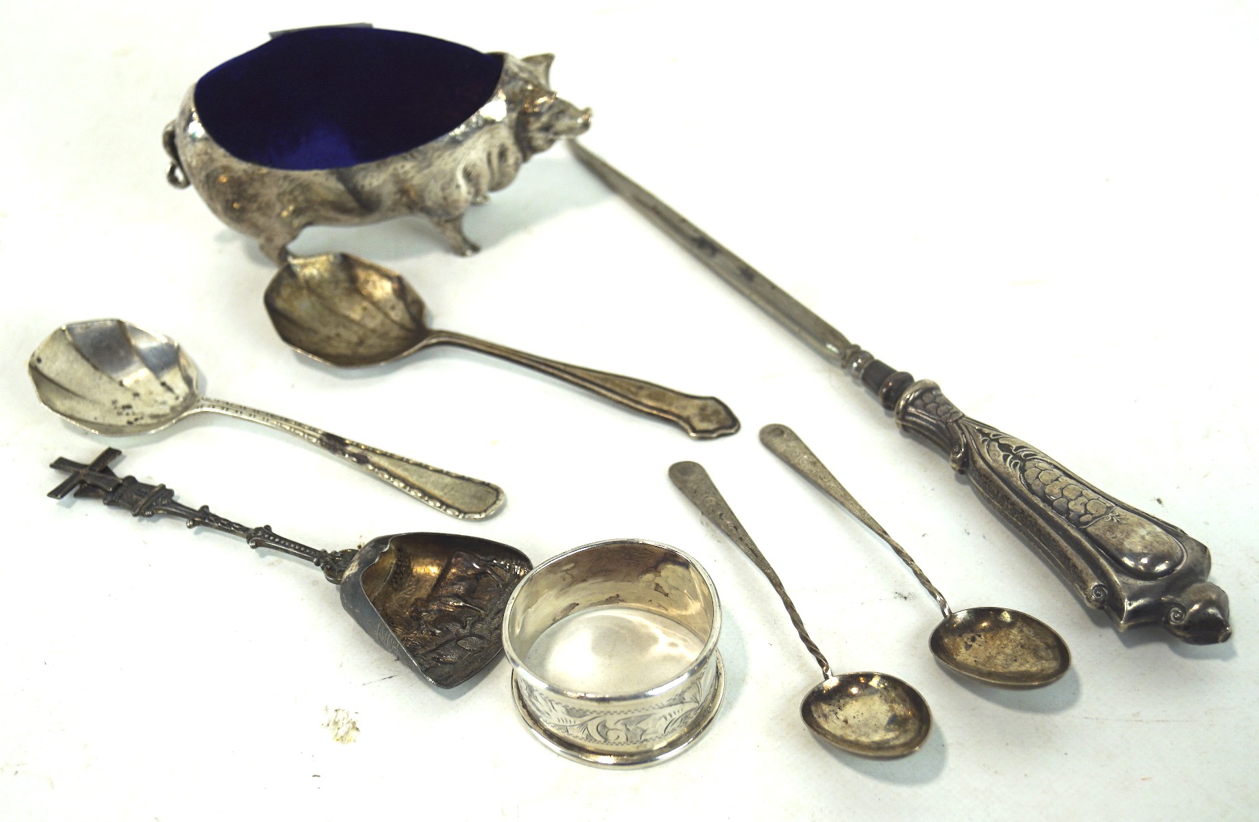 A selection of silver and white metal flatware and a silver plated pig pin cushion,
