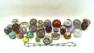 A collection of glass paperweights, to include one by Isle of White glass,