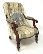 A Victorian button back chair with scrolled arms, on turned front legs and casters,