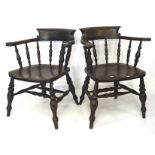 A pair of late 19th Century stained beech framed Captains chairs, each raised upon turned supports,