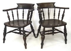 A pair of late 19th Century stained beech framed Captains chairs, each raised upon turned supports,