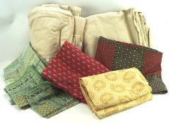 A collection of fabric, including polyester, cotton blends and linen, mostly tablecloths,