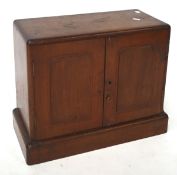 A mahogany mahogany two door medicine cabinet, with internal shelves, raised on a plinth base,