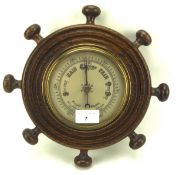 A 20th century barometer mounted in brass and oak in the shape of a ship's wheel,