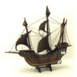 A painted wooden model galleon ship on a stand,