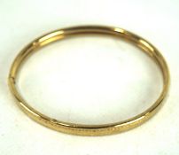 A 9ct gold bangle, with engraved decoration