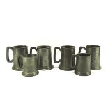 A colelction of six pewter mugs, two with glass bottoms, all with hammered decoration,
