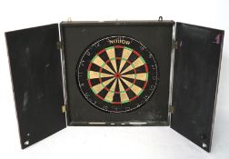 A contemporary dartboard in a double-doored case,