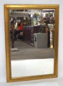 A contemporary gilt framed bevelled edge wall mirror, of rectangular form,