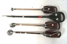 Four shooting sticks including three with leather seats,