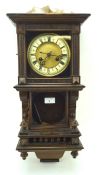 An early 20th century German wood cased wall clock, the face with Roman numerals denoting hours,