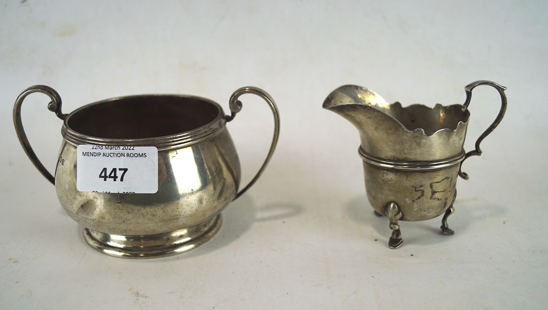 A late Victorian twin handled silver sugar bowl together with a silver cream jug,