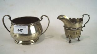 A late Victorian twin handled silver sugar bowl together with a silver cream jug,