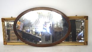 A 19th century oval mirror with inlaid banding and a contemporary rectangular gilt example,