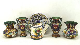 A group of colouful European pottery items including vases,