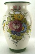 A large terracotta vase decorated with flowers on a cream ground,