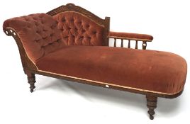 An Edwardian oak framed Chaise longue, with button back rest, raised on turned supports to castors,