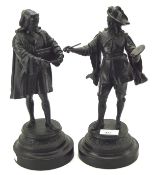 Two black painted metal figures, depicting figures in classical dress, both mounted on wooden bases,