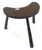 A late 19th century crescent moon shaped stool, with a leather work top, depicting a cloud dragon,