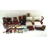 A collection of dolls house furniture and decorative items including beds, tables, dressers,