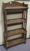 An early 20th century arts and crafts oak four tier bookcase, with pierced carved sides,