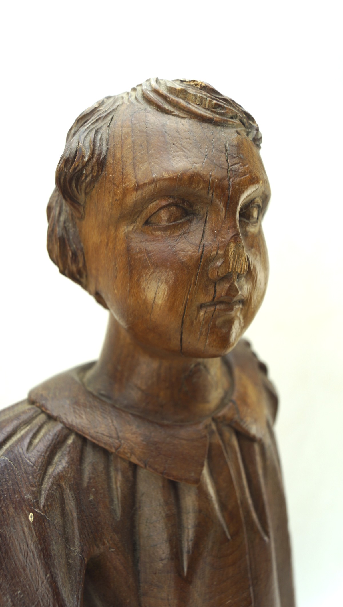 Large carved wooden figure of a young boy in a long collared coat, - Image 2 of 2