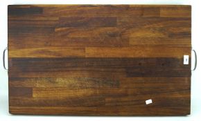 A contemporary hardwood chopping board, metal handles to either side,