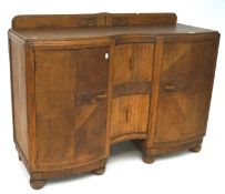 An early 20th century serpentine front oak sideboard with carved details,