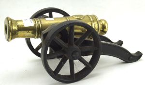 A brass and iron moveable model of a cannon on wheels