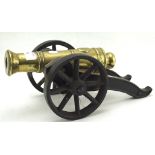 A brass and iron moveable model of a cannon on wheels