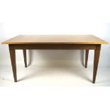 A contemporary wooden dining table, of rectangular form, on tapered square supports,