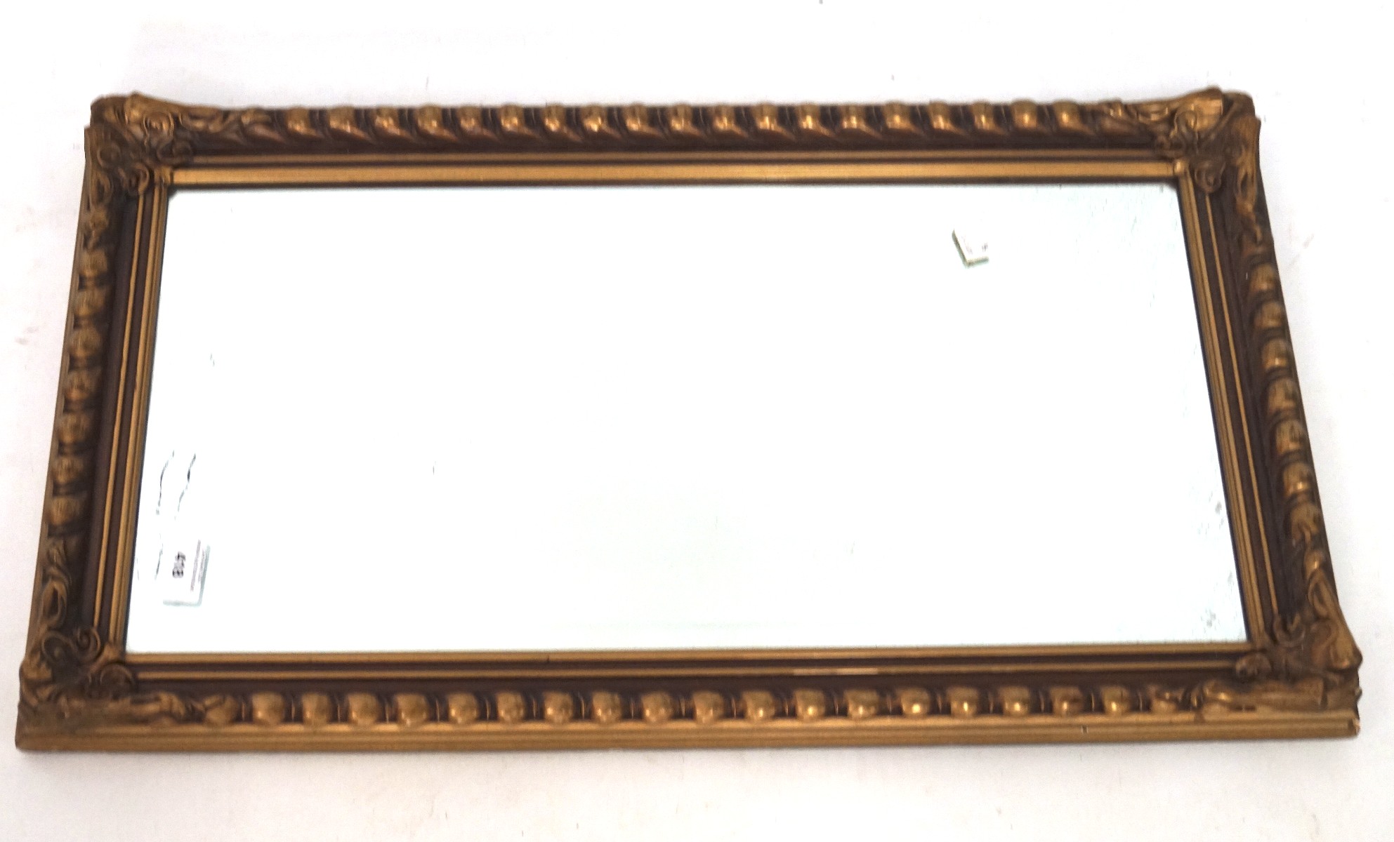 A contemporary gilt wall mirror with a moulded framed,